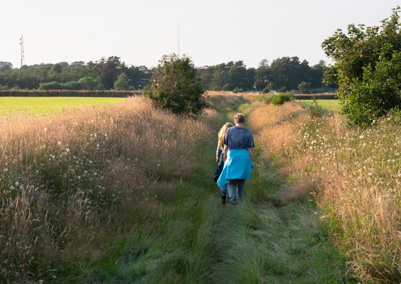 women hike on path in summer grass on dutch island of texel in holland